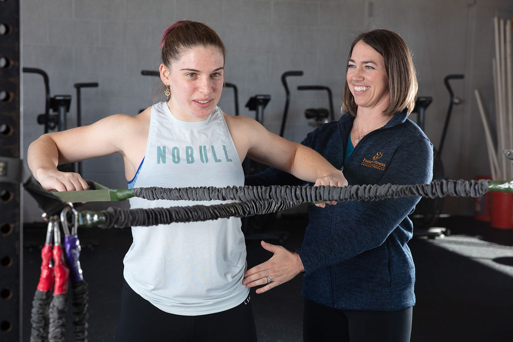 A physical therapist guiding a patient through a banded pull