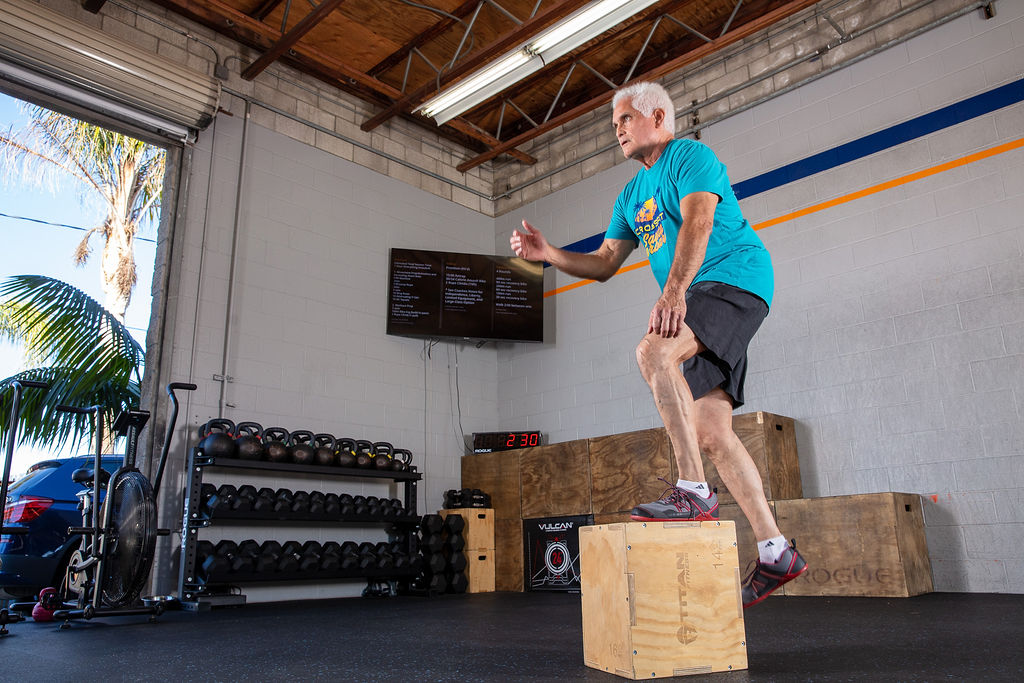 A patient stepping up onto a plyo box during post-op rehabilitation