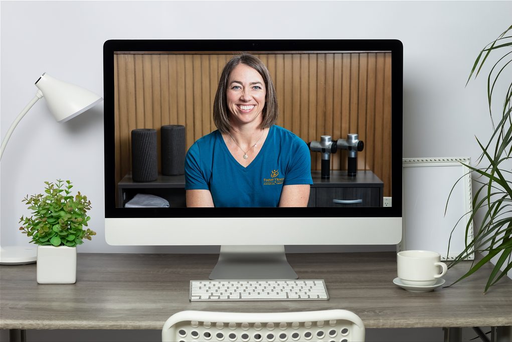 A physical therapist on a video call, shown on a desktop monitor